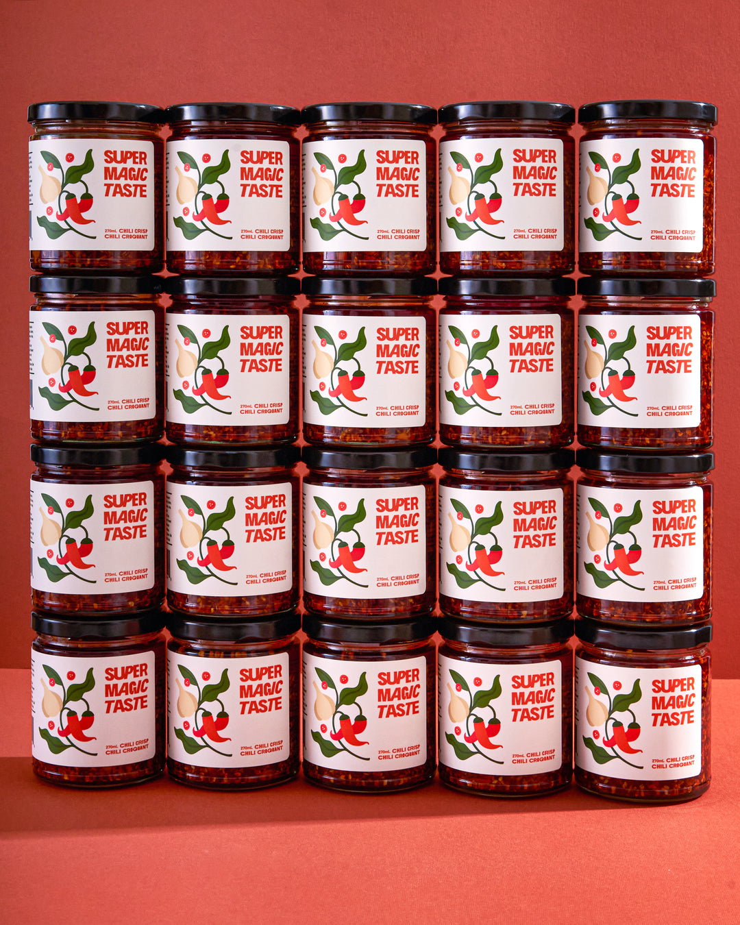 Twenty jars of Super Magic Taste Chili Crisp stacked in a grid, the twelve jar wholesale case.